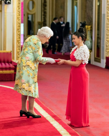 Queen Elizabeth II presenting Alexia with the 2018 Queen's Young Leaders Award