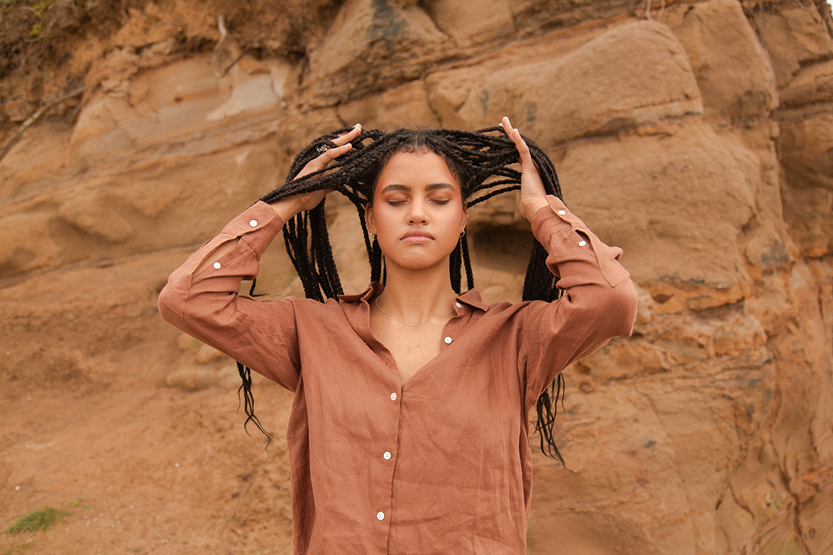 Woman combing her braided hair with her hands