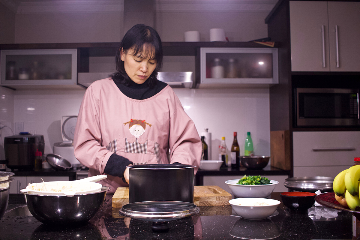 Woman in pink apron in kitchen